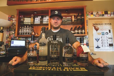 By Kyle Mittan Josh Mayr stands with his distillery's offerings. 