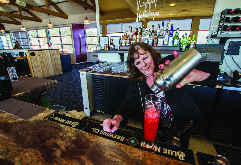 (Kyle Mittan | The Daily World) Bartender Supervisor Patty Eades pours a Pink Sand Verbena, the bar's signature drink made with gin, strawberry puree and grenadine.