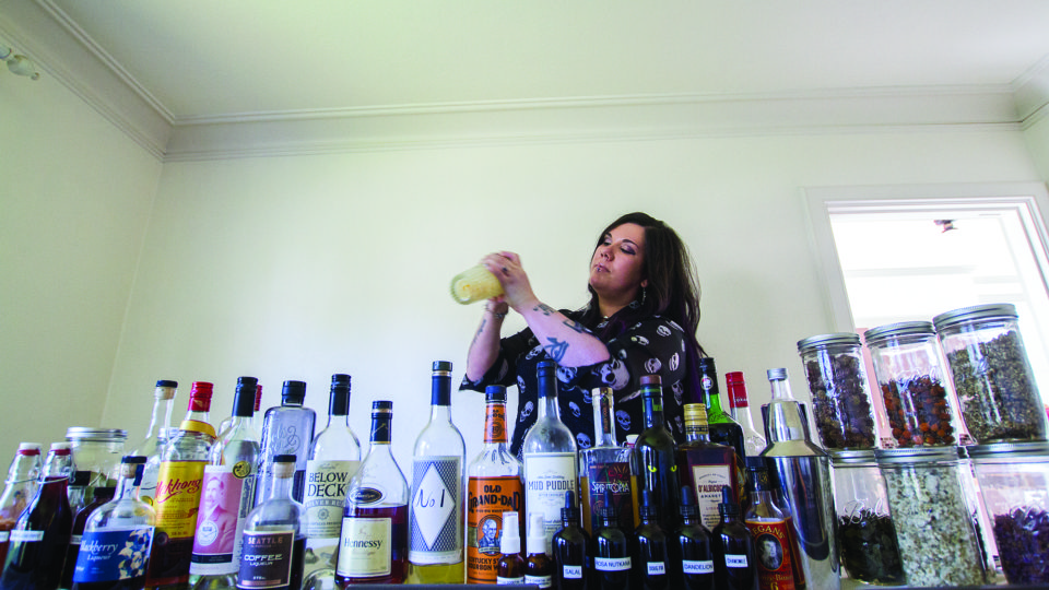 (Kyle Mittan) Izzy Ramos mixes a drink with a shaker at her in-home bar.
