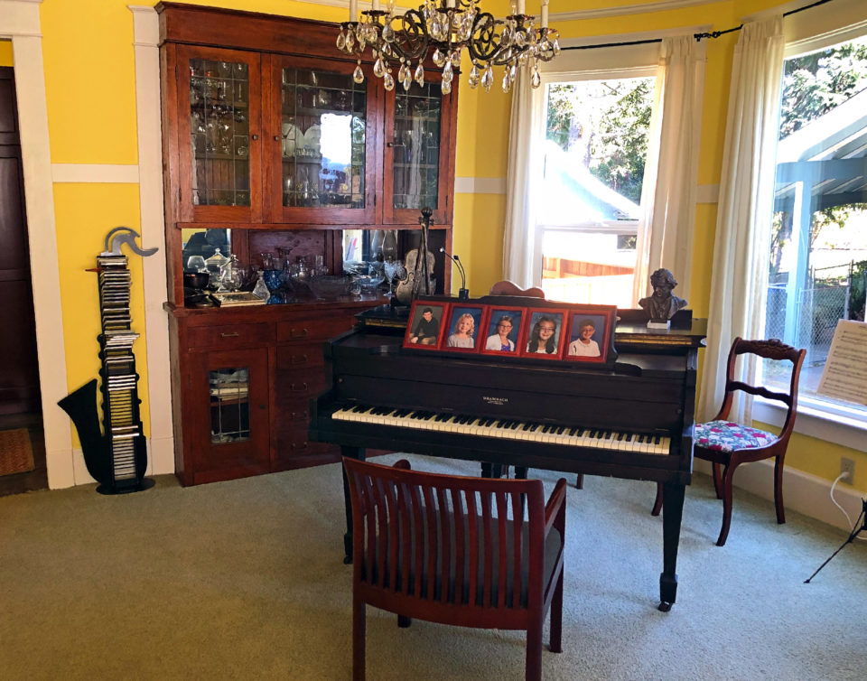 One side of the main floor is painted in bright colors. Sherry says she just plunks on the piano a bit, but some of the younger family members are showing interest in the piano. This room may originally have been a dining room, adjacent to one of the two original kitchens.